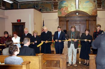 Dignitaries cut a ribbon to symbolize the formal rededication of the courthouse for its 100th anniversary.